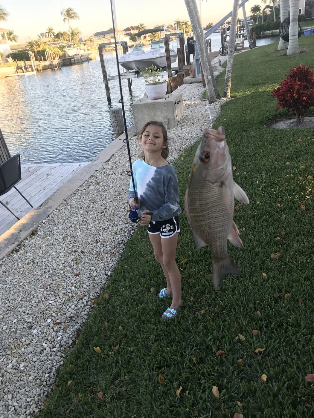 Young angler holding a fish on a dock